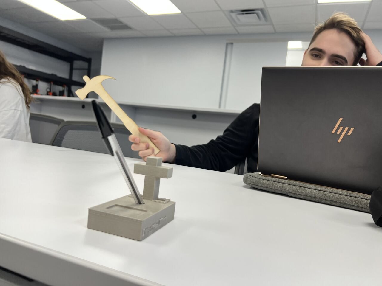 A student demonstrating a 3D-printed tool and pen holder