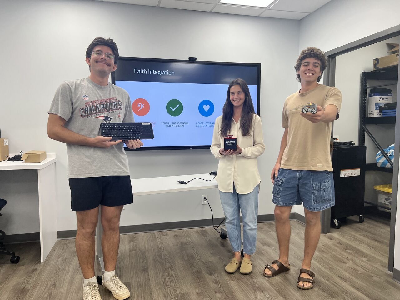Students presenting control hardware and a mobile robot